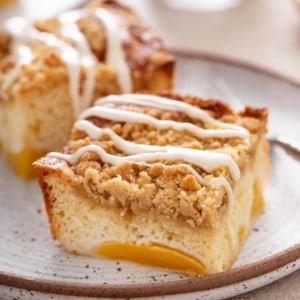 Two slices of easy peach coffee cake on a speckled plate.