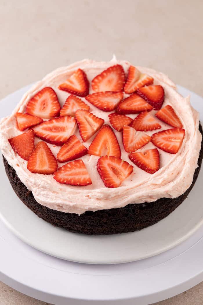 Single layer of chocolate cake topped with strawberry frosting and sliced fresh strawberries.