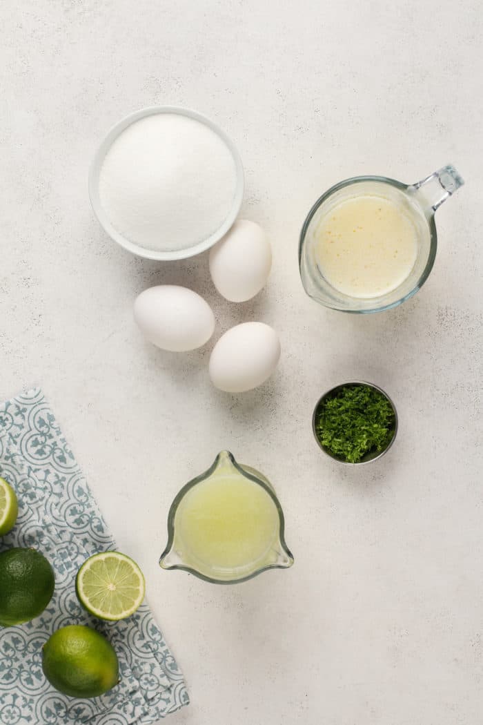 Lime curd ingredients arranged on a gray countertop.