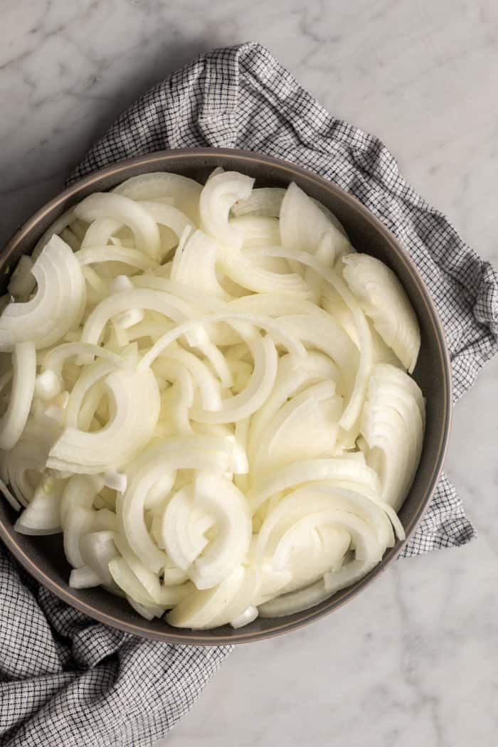 Sliced onions in a large, high-sided skillet.