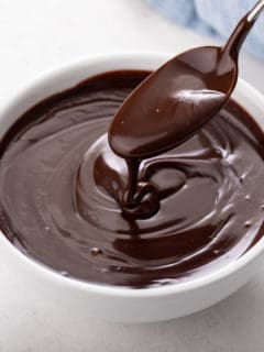 Bowl of chocolate ganache with a spoon in it.