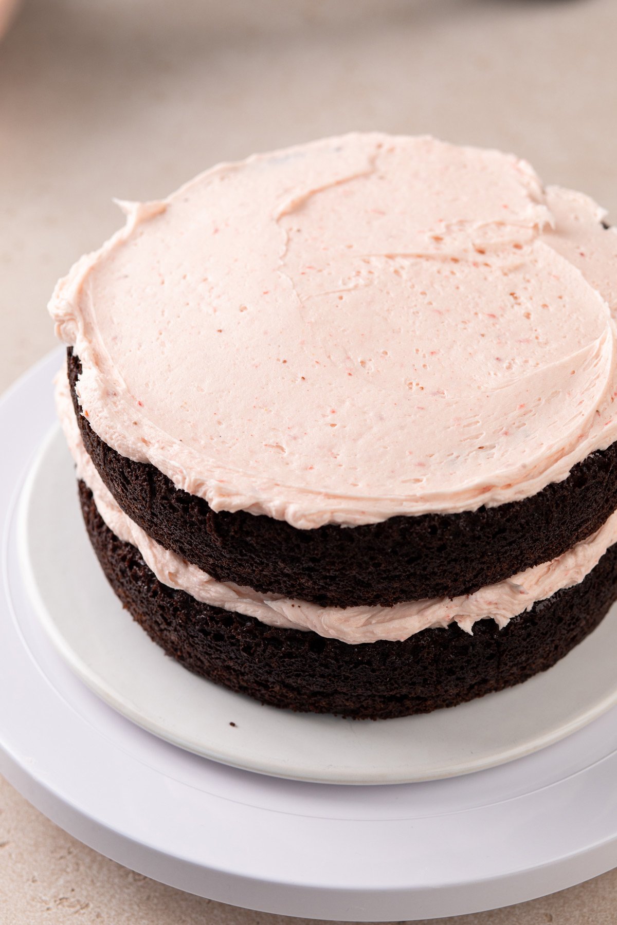 Two layers of chocolate cake, each topped with strawberry frosting.