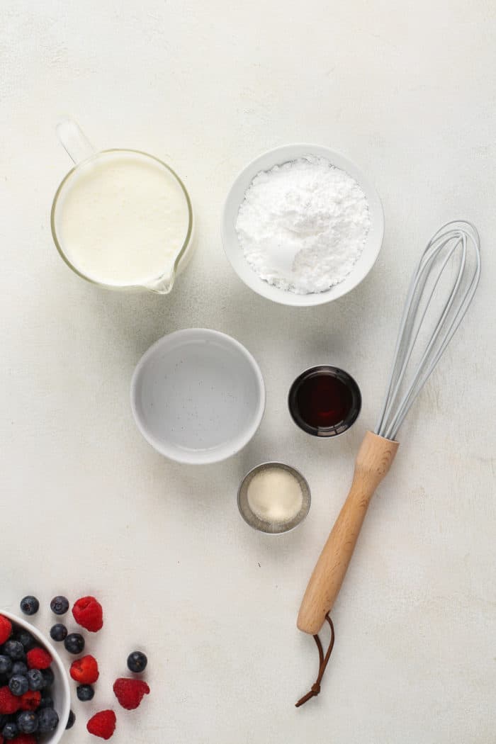 Ingredients for whipped cream frosting arranged on a countertop.