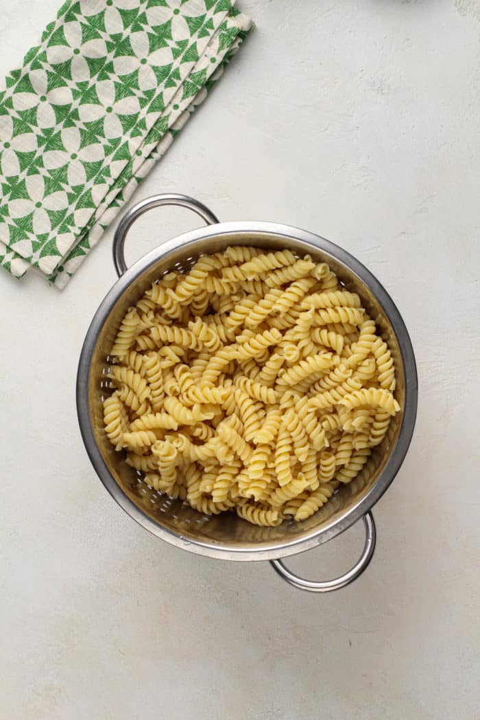 Cooked and drained rotini pasta in a colander for pasta salad.
