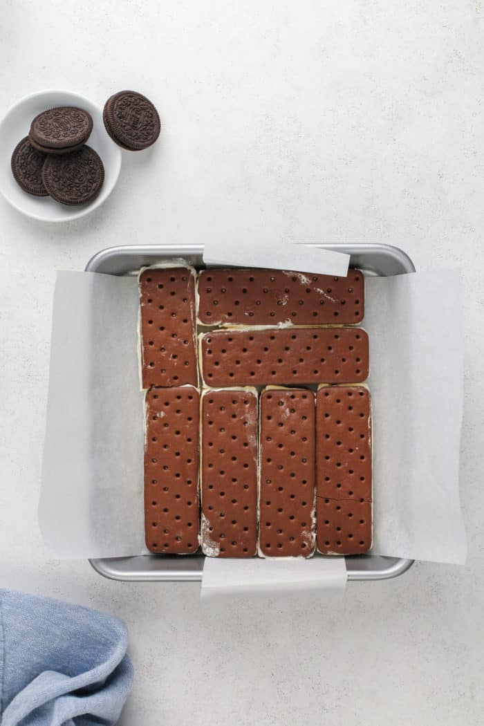 Ice cream sandwiches arranged in the bottom of a square cake pan.