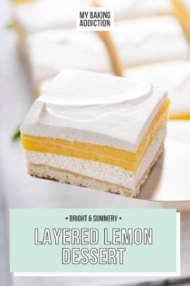 Cake server holding up a slice of layered lemon dessert, with more slices visible in the background. Text overlay includes recipe name.