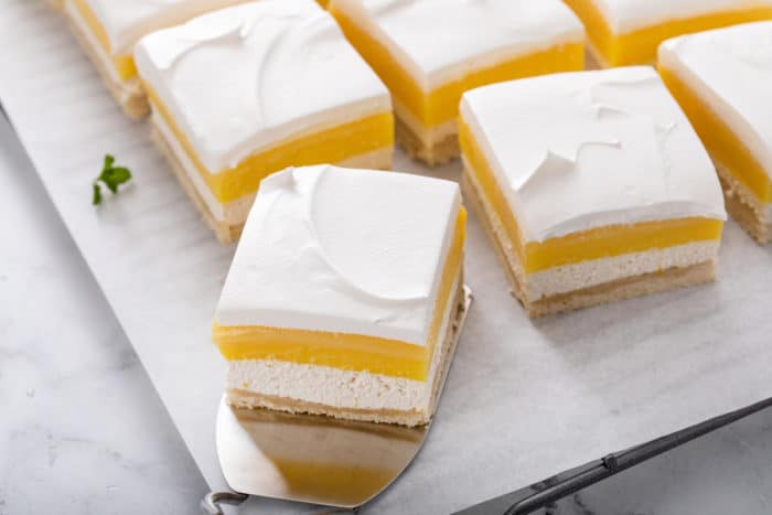 Slices of layered lemon dessert on a piece of parchment paper.