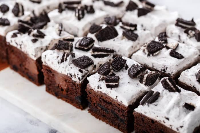 Slices of oreo poke cake arranged on a white board.