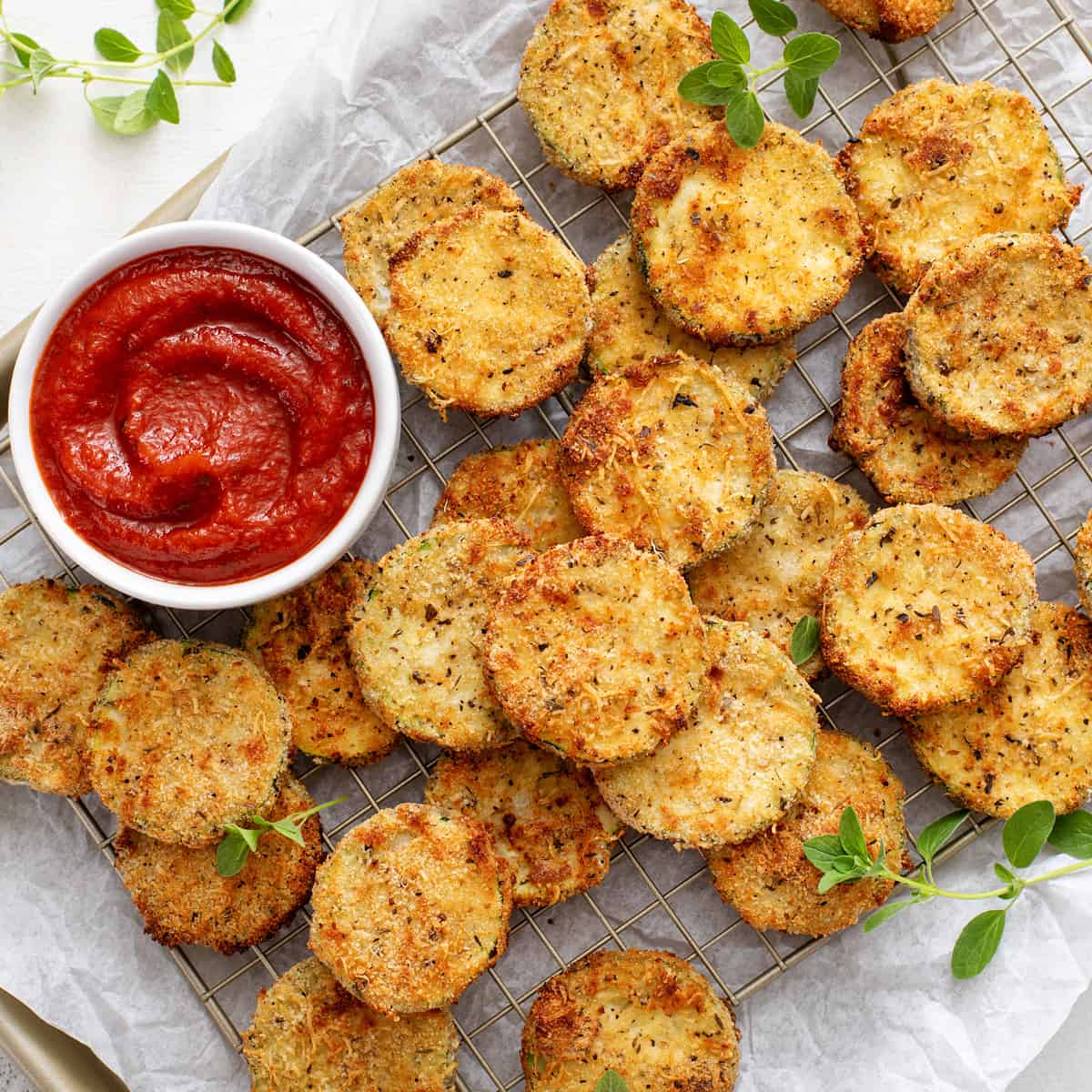 https://www.mybakingaddiction.com/wp-content/uploads/2023/08/air-fried-zucchini-chips-on-pan-hero.jpg