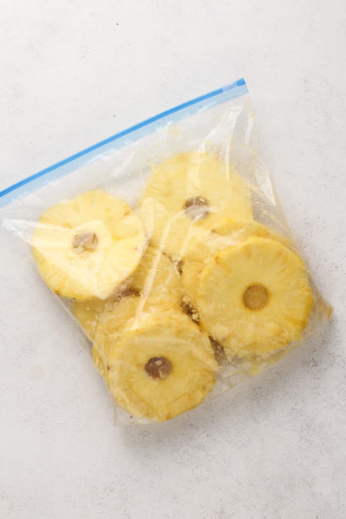 Sliced fresh pineapple in a zip-top bag with a brown sugar marinade.