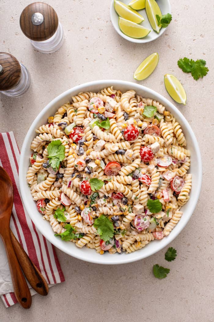 Overhead view of a large, white serving bowl filled with southwest pasta salad.