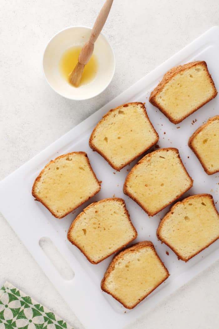 Slices of pound cake being brushed with a honey and butter mixture.
