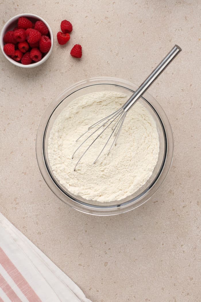 Dry ingredients for raspberry lemon cookies in a glass mixing bowl.