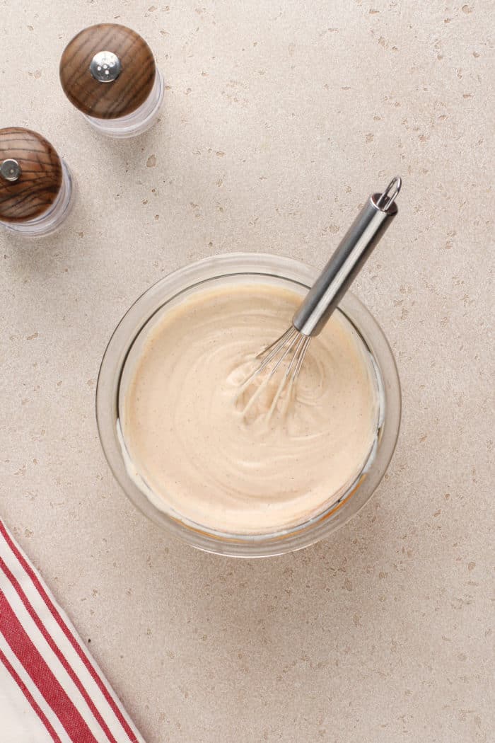 Dressing for southwest pasta salad being whisked together in a glass bowl.