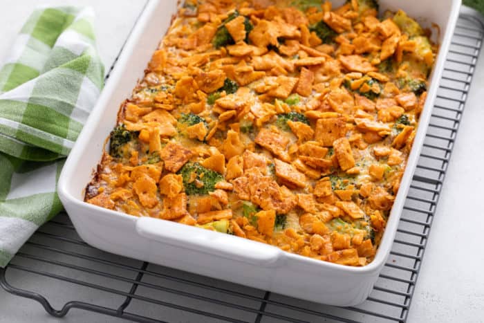 White baking dish filled with broccoli casserole resting on a wire cooling rack.