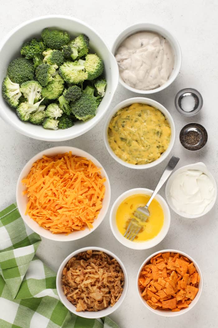 Ingredients for broccoli casserole arranged on a white countertop.