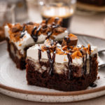 Close up image of two slices of butterfinger poke cake on a plate.