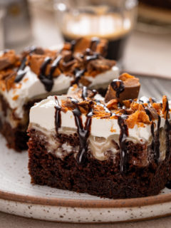 Close up image of two slices of butterfinger poke cake on a plate.