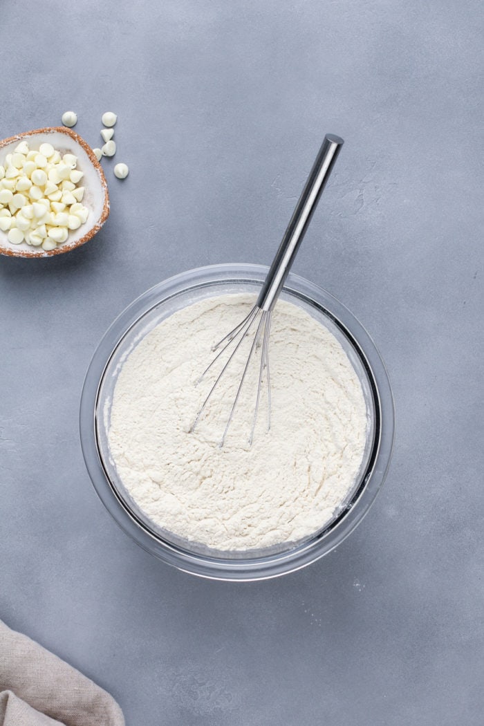 Dry ingredients for white chocolate macadamia nut cookies whisked in a glass bowl.