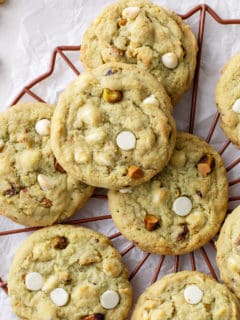White chocolate pistachio pudding cookies arranged on a wire rack.