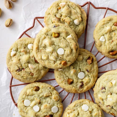White chocolate pistachio pudding cookies arranged on a wire rack.