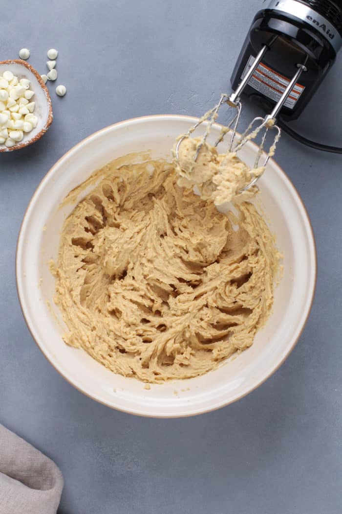 Wet ingredients for white chocolate macadamia nut cookies mixed in a white bowl.