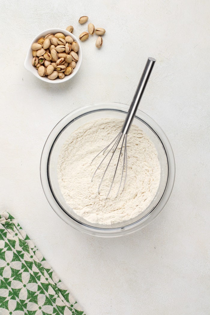 Dry ingredients for white chocolate pistachio pudding cookies whisked together in a glass mixing bowl.