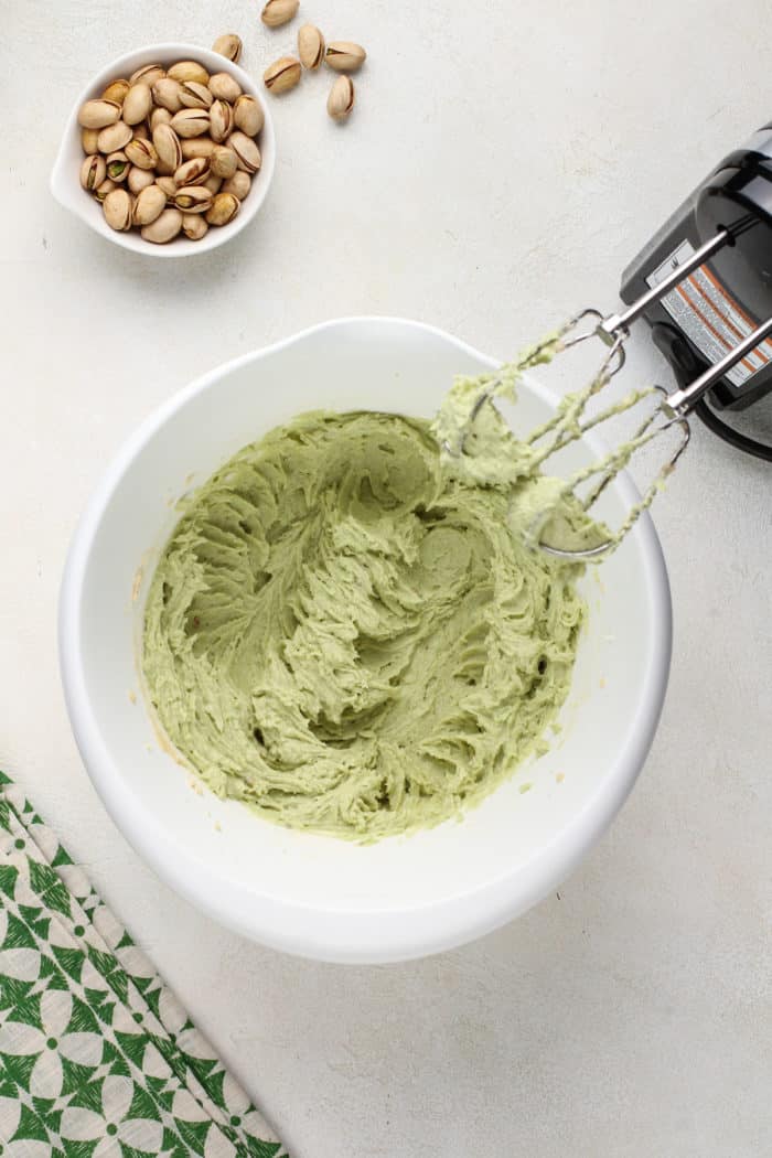 Wet ingredients for white chocolate pistachio pudding cookies mixed together in a white mixing bowl.