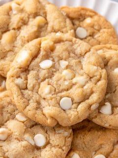 close up of white chocolate macadamia nut cookies on a plate.