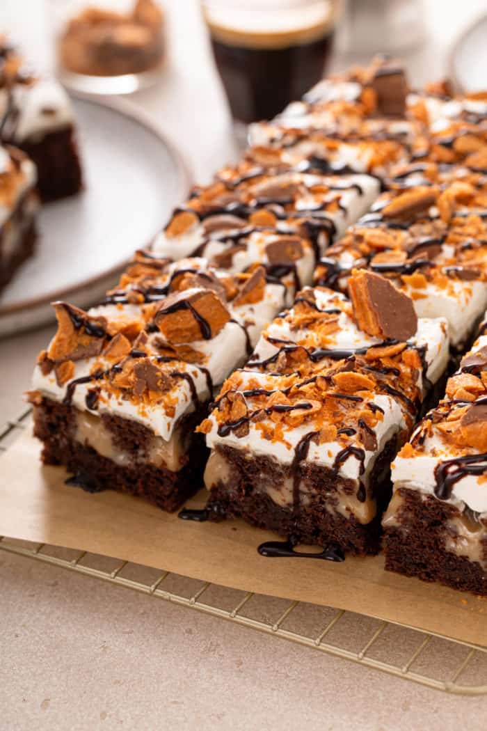 Sliced butterfinger poke cake on a piece of parchment paper.