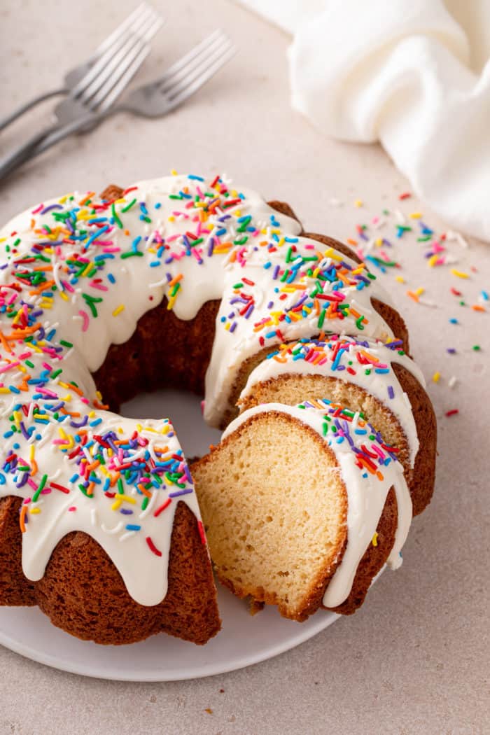 Sliced vanilla bundt cake on a white cake plate.