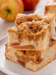 Two slices of easy apple coffee cake stacked on a white plate.
