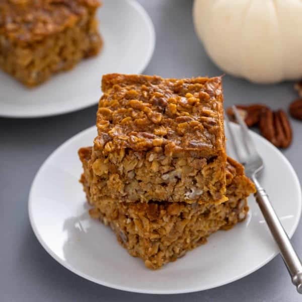 Two slices of pumpkin baked oatmeal stacked on a plate.