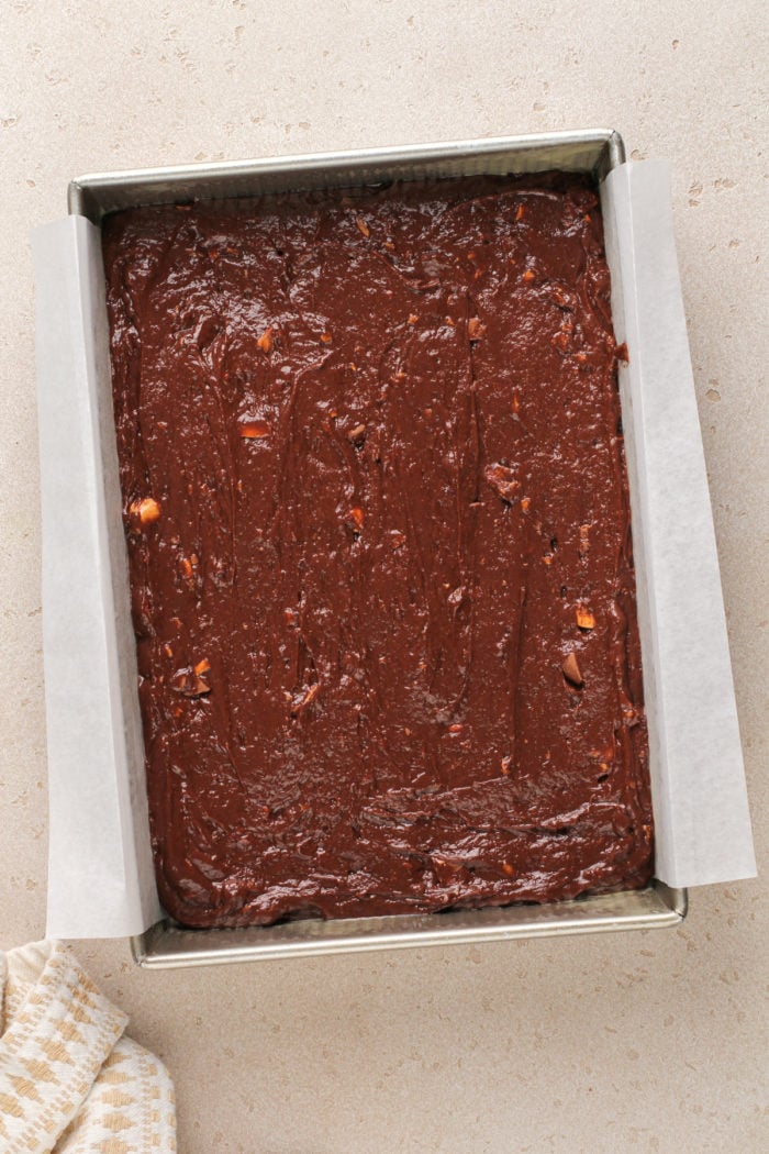 Chocolate butterfinger cake batter in a cake pan, ready to go in the oven.