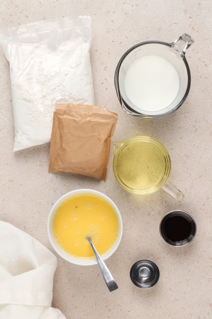 Easy vanilla bundt cake ingredients arranged on a beige countertop.