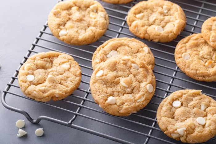 White chocolate macadamia nut cookies on a wire cooling rack.
