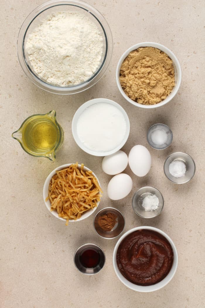 Ingredients for apple butter cake arranged on a beige countertop.
