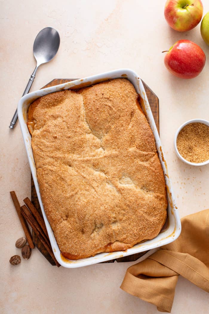 Baked apple cobbler in a white casserole dish.