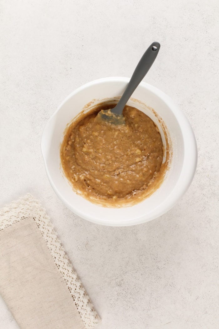 Batter base for banana nut muffins in a white mixing bowl.