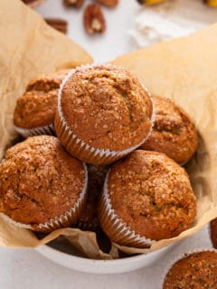 Banana nut muffins in a parchment-lined bowl.