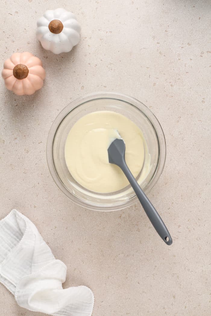 Cream cheese filling for pumpkin cream cheese pie in a glass mixing bowl.