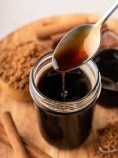Spoon drizzling brown sugar syrup back into a jar.