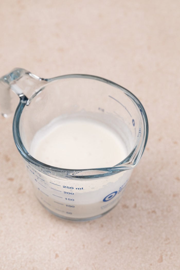 Frothed vanilla sweet cream cold foam in a glass measuring cup.