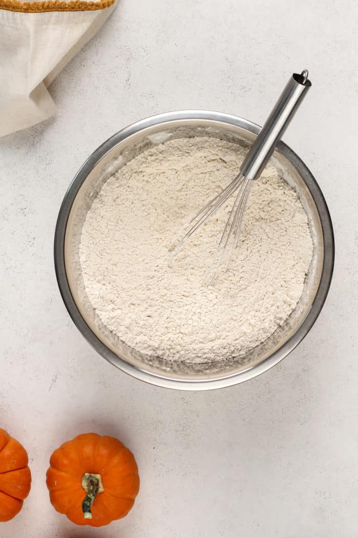 Dry ingredients for pumpkin bread in a metal mixing bowl.