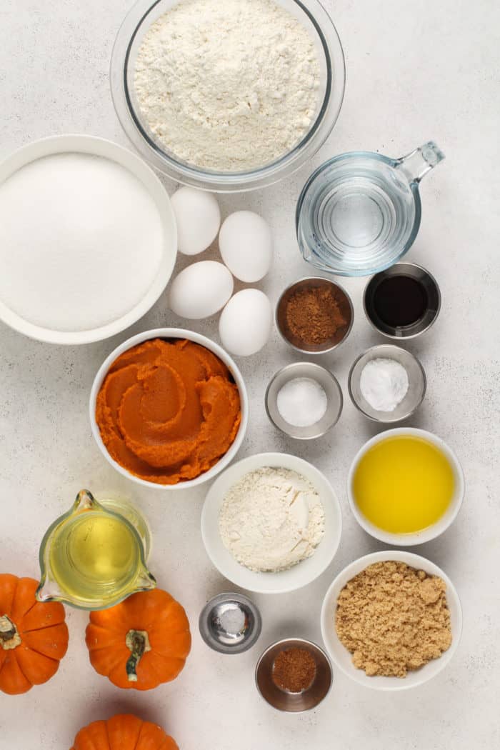 Ingredients for pumpkin bread arranged on a light-colored countertop.