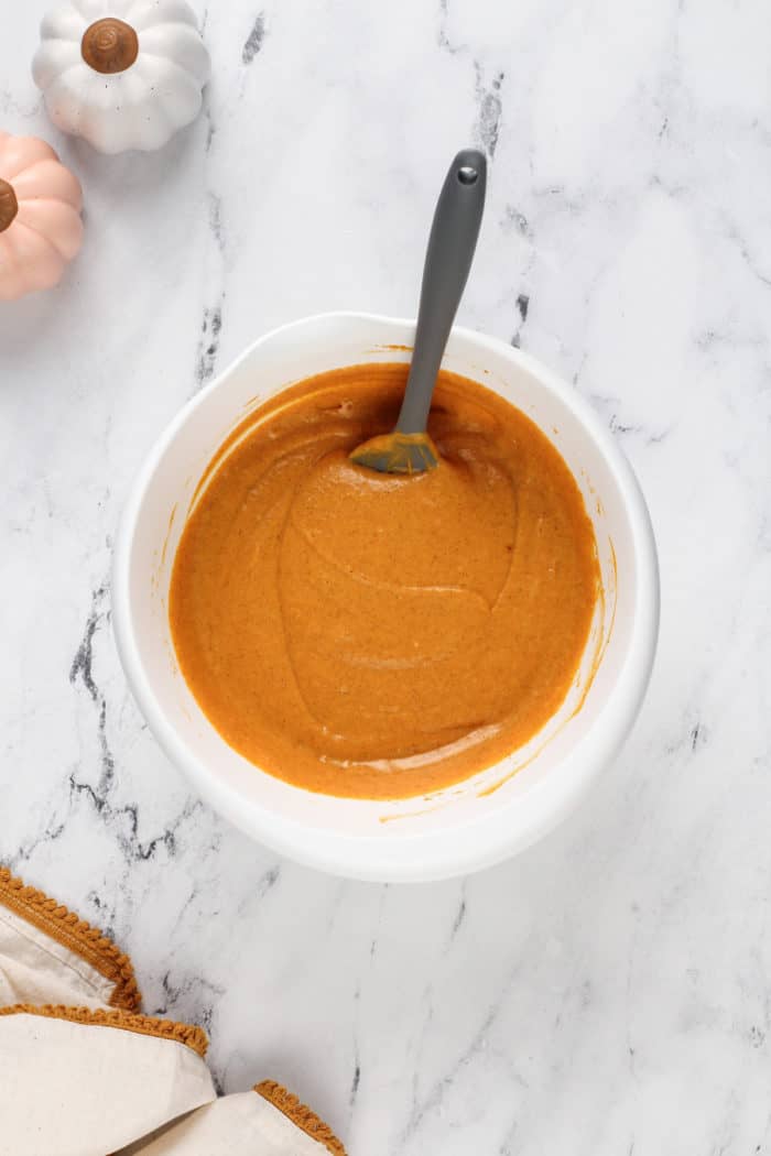 Pumpkin filling for pumpkin gooey butter cake in a white mixing bowl.