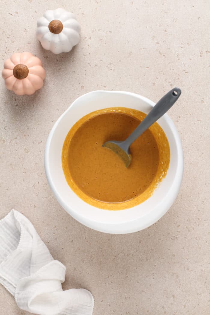 Pumpkin pie filling in a white mixing bowl.