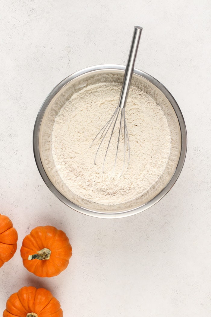 Dry ingredients for pumpkin snickerdoodles in a metal mixing bowl.