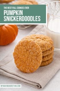 Four pumpkin snickerdoodles stacked on a cloth napkin with a fifth cookie leaning against the stack. text overlay includea recipe name.