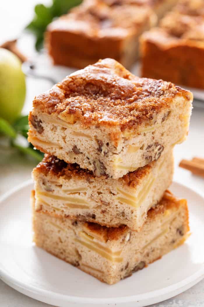 Three slices of homemade apple cake stacked on a white plate.
